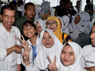 Presiden Joko Widodo berfoto bersama sejumlah siswa saat acara penyerahan KIP dan PKH di Kota Banjarbaru, Kalimantan Selatan (26/3). (Liputan6.com/Pool/Biro Setpres)