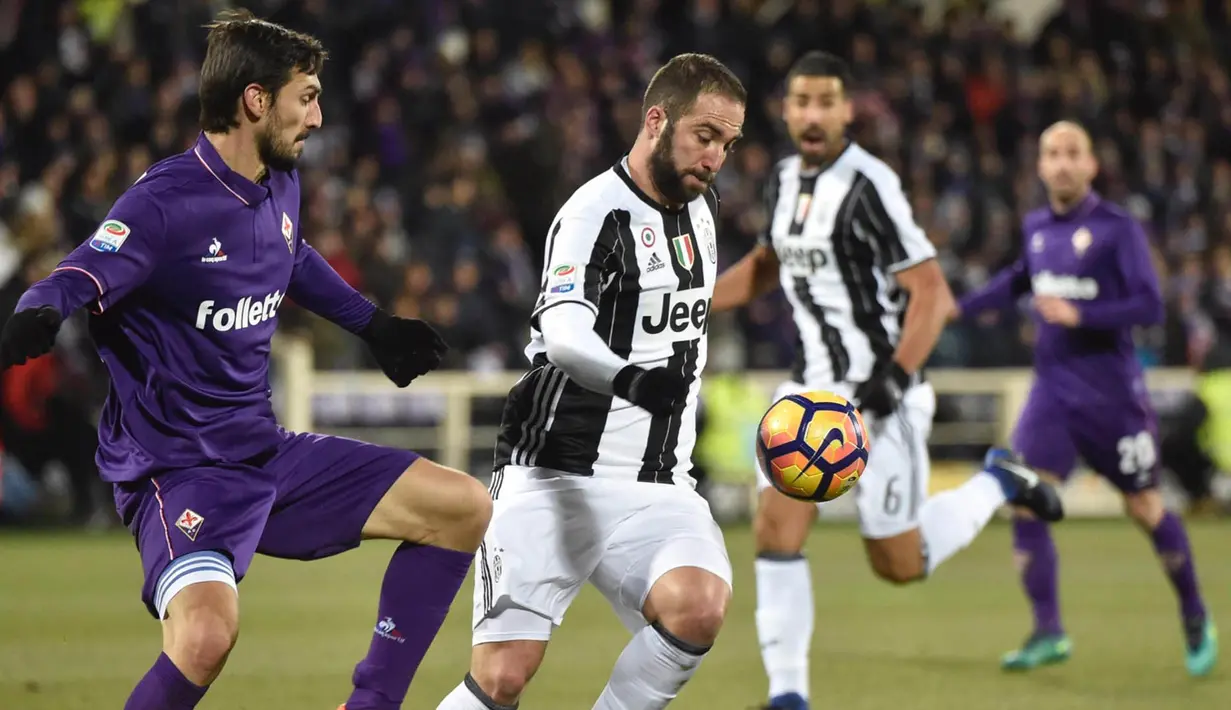 Penyerang Juventus, Gonzalo Higuain, berusaha melewati hadangan bek Fiorentina, Davide Astori. Pada laga ini Juventus turun dengan skema 3-5-2, sementara Fiorentina memakai formasi 3-5-1-1. (EPA/Maurizio Degl' Innocenti)