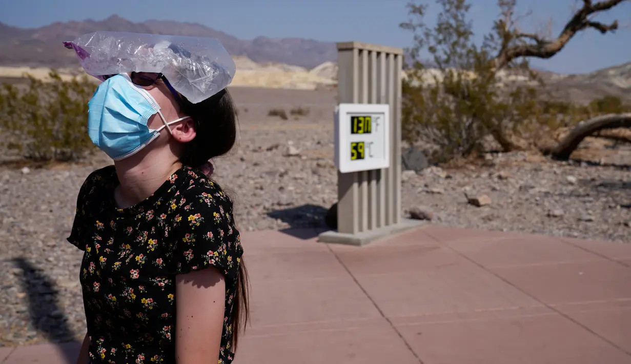 Katie Moore mendinginkan kepalanya dengan sekantong es di Taman Nasional Death Valley, California, AS, Senin (17/8/2020). Suhu terpanas di dunia terpantau terjadi di Taman Nasional Death Valley yang mencapai 130 derajat Fahrenheit (54,4 derajat Celcius) pada Minggu 16 Agustus. (AP Photo/John Locher)