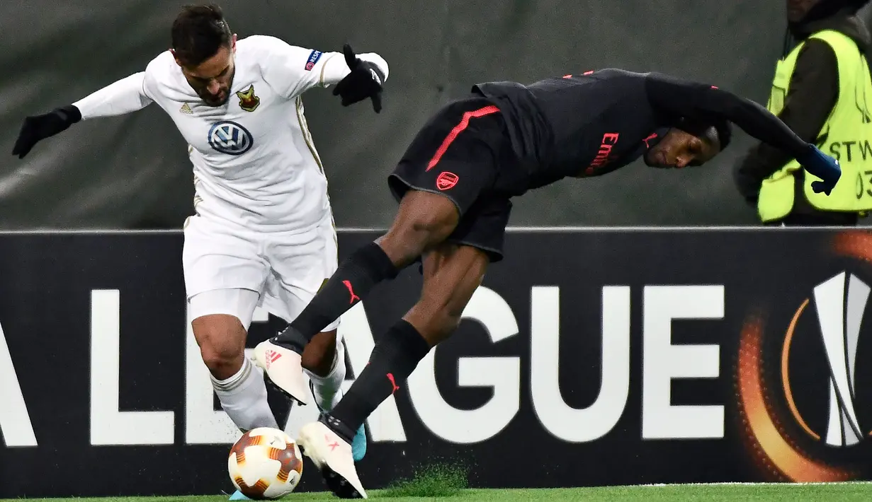 Pemain Ostersunds, Sotirios Papagiannopoulos merebut bola dari  pemain Arsenal, Danny Welbeck pada laga leg pertama babak 32 besar Liga Europa di Jamtkraft Arena, Jumat (16/2). Arsenal meraih kemenangan mudah 3-0. (Robert Henriksson/TT News Agency via AP)