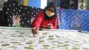 Perajin batik sedang menyelesaikan proses pembuatan batik tulis di Sanggar Batik Kembang Mayang, Larangan, Tangerang, Banten, Minggu (19/7/2020). Kain batik tulis dengan motif khas Tangerang ini dijual mulai dari Rp 450.000. (Liputan6.com/Angga Yuniar)