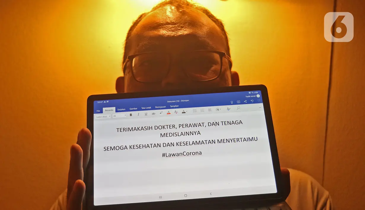 Seorang karyawan menunjukkan tulisan dukungan di kawasan Rawa Belong, Jakarta, Senin (23/3/2020). Warga memberikan dukungan kepada tenaga medis yang berjuang dan berdedikasi dalam penanganan Covid-19. (Liputan6.com/Herman Zakharia)