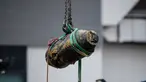Alat berat mengangkat bom era Perang Dunia II yang ditemukan di lokasi konstruksi di distrik padat Wan Chai, Hong Kong, Kamis (1/2). Para ahli bekerja semalaman untuk menjinakkan bom seberat 450 kg tersebut. (AFP/ Anthony WALLACE)