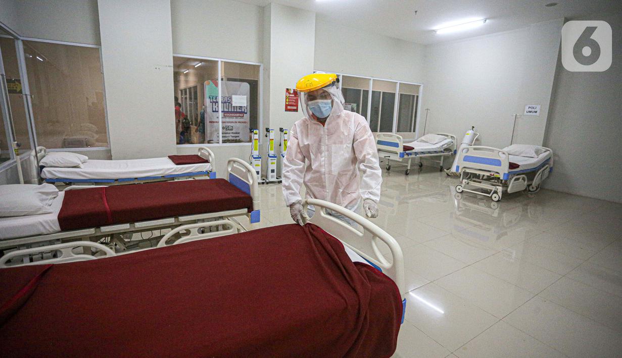 Petugas mengenakan hazmat saat menyiapkan tempat tidur di Tower 8 Wisma Atlet Pademangan, Jakarta, Selasa (15/6/2021). Koordinator Lapangan RSDC Wisma Atlet Letkol Marinir M. Arifin mengatakan soal alternatif Tower 8 Wisma Atlet Pademangan untuk pasien OTG COVID-19. (Liputan6.com/Faizal Fanani)