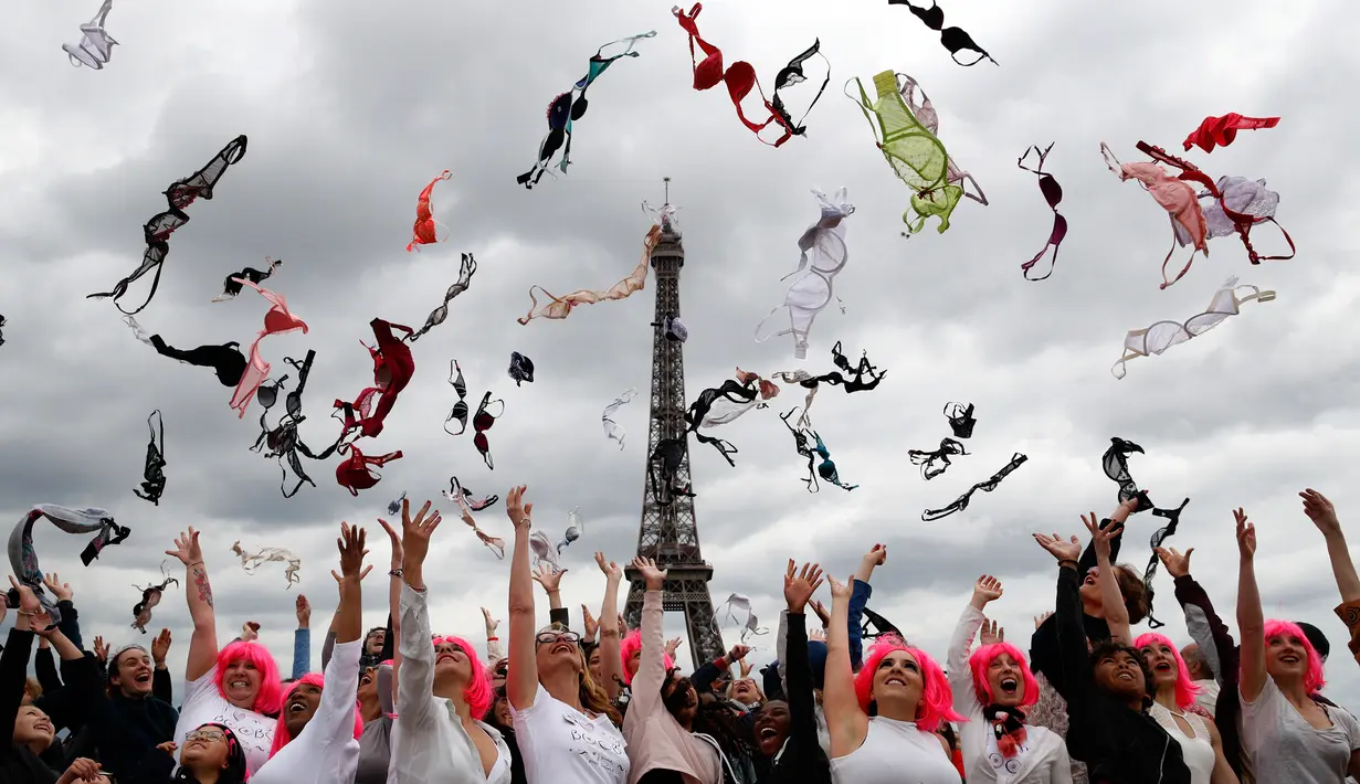 Aksi puluhan wanita melemparkan bra mereka ke udara saat acara tahunan "Pink Bra Toss" di depan Menara Eiffel, Paris, Minggu (13/5). Acara ini dalam rangka mendukung para wanita dalam menjaga kesehatan payudara dari bahaya kanker. (AP/Christophe Ena)