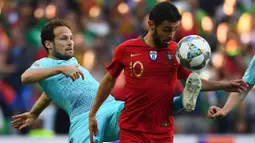 Gelandang Portugal, Bernardo Silva, berusaha melewati bek Belanda, Daley Blind, pada laga final UEFA Nations League di Stadion Dragao, Porto, Minggu (9/6). Portugal menang 1-0 atas Belanda. (AFP/Gabriel Bouys)