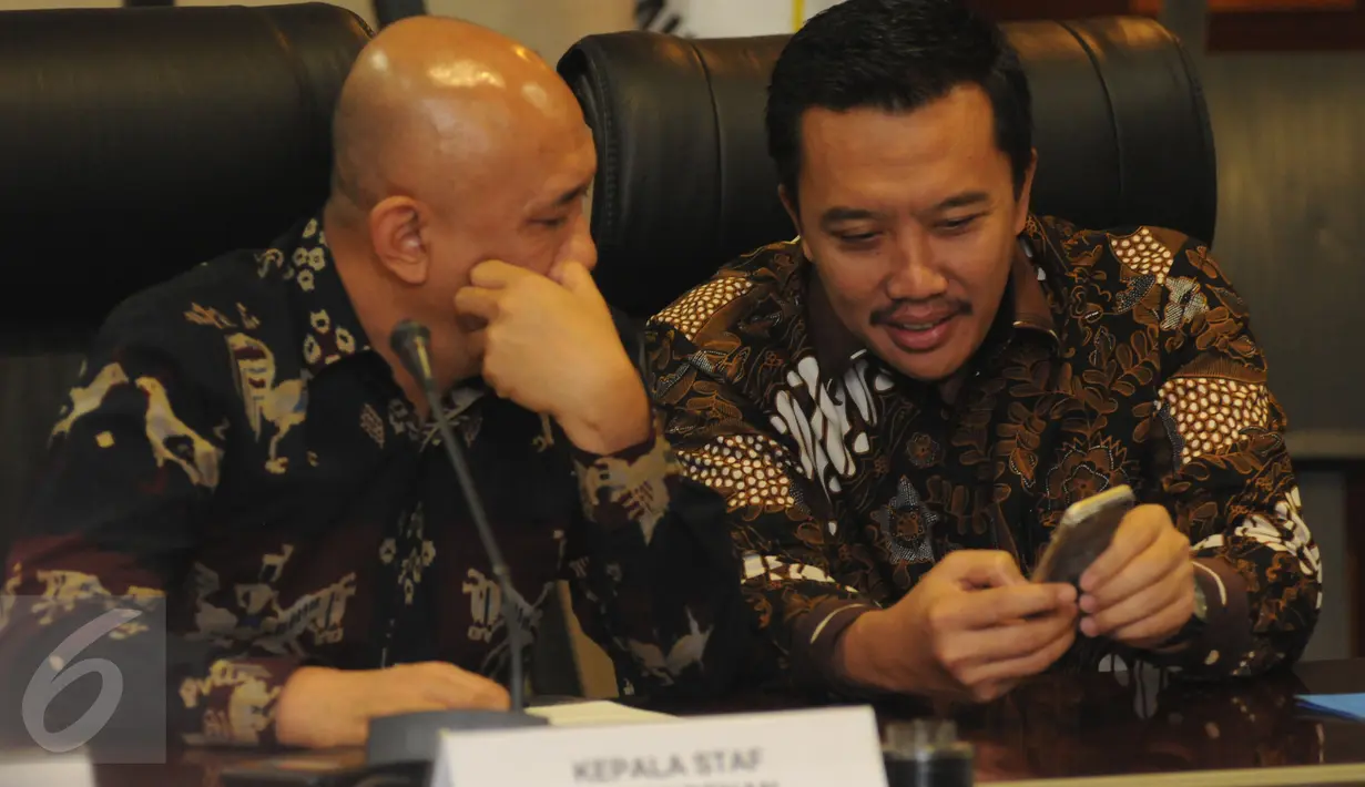 Menpora Imam Nahrawi (kanan) memperlihatkan sesuatu pada Kepala Staf Kepresidenan Teten Masduki jelang peluncuran logo baru Asian Games 2018 di Kantor KSP Jakarta, Kamis (28/7). Logo bertema The Energy of Asia. (Liputan6.com/Helmi Fithriansyah)
