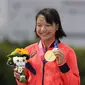 Skater Jepang Momiji Nishiya memegang medali emas setelah memenangkan final street skateboarding putri Olimpiade Tokyo 2020 di Tokyo, Jepang, 26 Juli 2021. Saat ini, Momiji tercatat sebagai atlet termuda yang sukses mendulang emas di Olimpiade. (AP Photo/Ben Curtis)