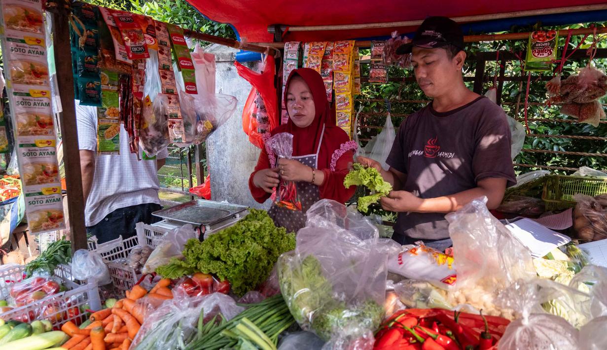 Seorang pembeli (kanan) membeli sayuran dari sebuah kios di pasar tradisional di Jakarta pada Rabu 3 Juni 2026. (BAY ISMOYO/AFP)