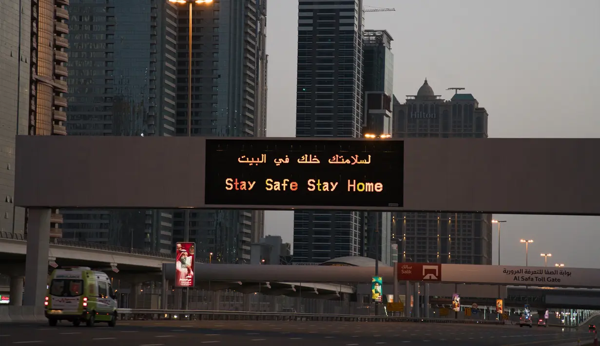 Sebuah ambulans melintasi Jalan Sheikh Zayed 12 yang sepi di Dubai, Uni Emirat Arab, Minggu (5/4/2020). Selama lockdown, warga Dubai dilarang meninggalkan rumah kecuali untuk urusan mendesak dan penting. (AP Photo/Jon Gambrell)