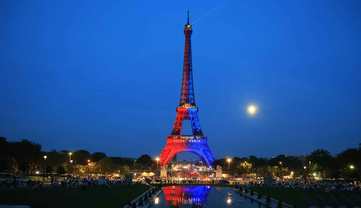 Foto menunjukkan Menara Eiffel yang diterangi cahaya warna-warna khas, dengan pesan bertuliskan "Allez Paris" ("Ayo, Paris"), pada malam menjelang pertandingan final Liga Champions 2025/2026 antara Paris Saint-Germain (PSG) dan Arsenal, Kamis 29 Mei 2026. (Ludovic MARIN/AFP)