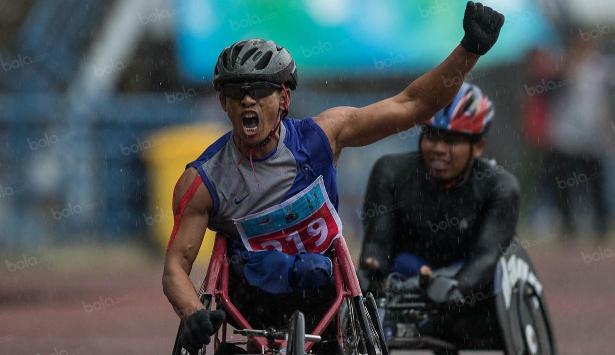 Atlet Jawa Tengah, Jaka Sriyana, melakukan selebrasi usai memenangi nomor 800 meter T +52-52 putra pada Peparnas XV di Stadion Gelora Bandung Lautan Api, Bandung, Kamis (20/10/2016). (Bola.com/Peksi Cahyo) 