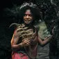 Closeup gadis muda eksotis Suku Dani dari Papua dengan pakaian tradisional tersenyum di tengah hutan. Foto: Freepik.