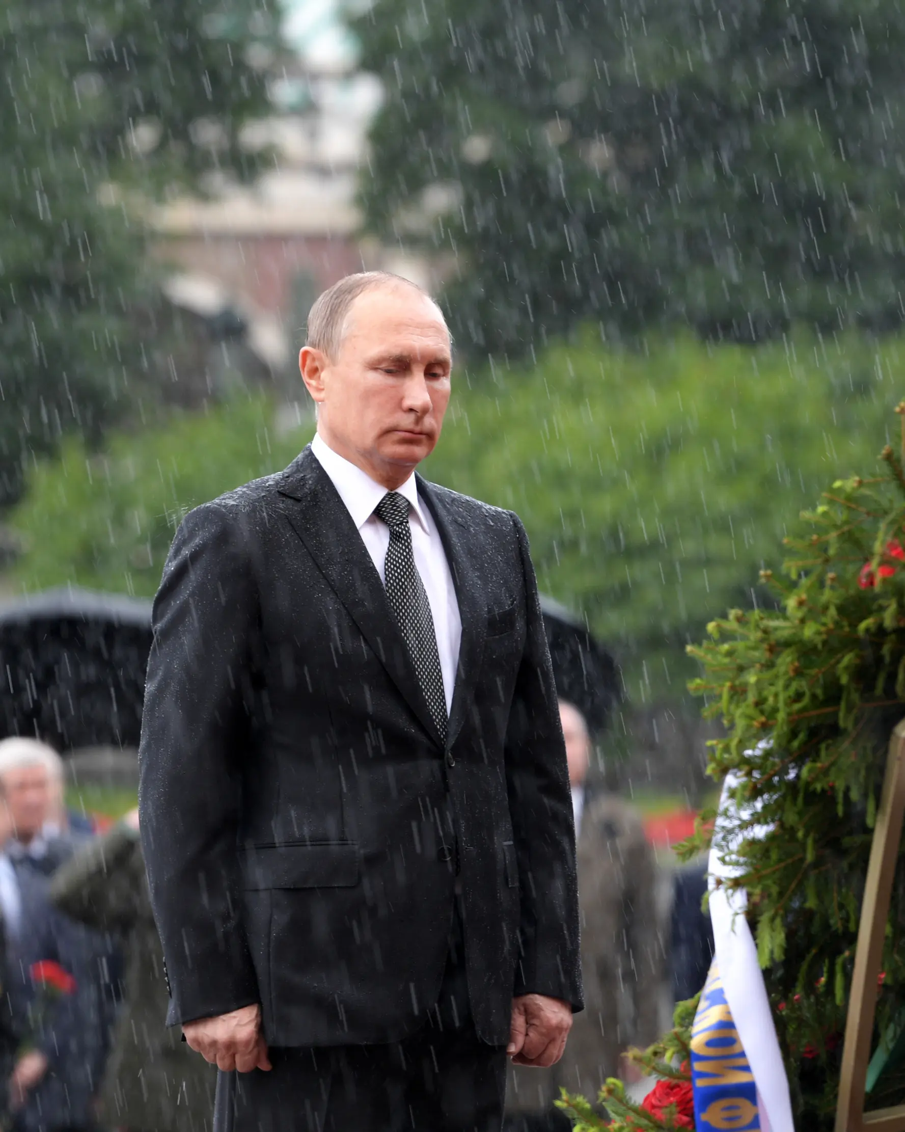 Presiden Rusia Vladimir Putin berdiri di tengah hujan selama upacara kehormatan untuk memperingati invasi Nazi Jerman pada 1941 di Benteng Kremlin, di Moskow, Kamis (22/6). (Alexei Druzhinin/Sputnik, Kremlin Pool Photo via AP)