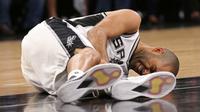Guard San Antonio Spurs, Tony Parker, mengerang kesakitan sambil memegang kakinya yang cedera pada gim 2 semifinal Wilayah Barat kontra Houston Rockets di AT&T Center, San Antonio, Rabu (3/5/2017). (The San Antonio Express-News via AP/Jerry Lara)