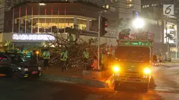 Petugas Dinas Kehutanan DKI Jakarta memuat rangkaian instalasi bambu Getah Getih ke dalam truk di Bundaran Hotel Indonesia (HI), Kamis (18/7/2019) dini hari. Karya seni tersebut rencananya akan diganti dengan taman dan bambu itu akan dibawa ke tempat pembuangan sampah. (Liputan6.com/Herman Zakharia)