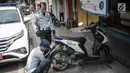 Petugas Dishub DKI Jakarta merazia  kendaraan roda dua dengan mencopot pentil yang terparkir di trotoar di kawasan Cipete Raya, Jakarta, Selasa (13/8/2019). Razia tersebut dilakukan Dishub untuk mengembalikan fungsi trotoar untuk pejalan kaki. (Liputan6.com/Faizal Fanani)