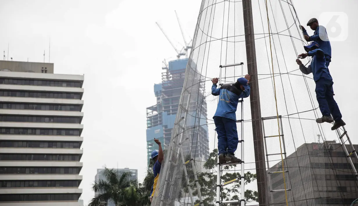 Pekerja memasang rangka pohon natal di Thamrin 10, Jakarta, Kamis (19/12/2019). Warga dapat melihat Christmas Tree pada 18-31 Desember 2019. yang dibuat dari bahan daur ulang botol dan kain perca dengan mengangkat nuansa Nusantara. (Liputan6.com/Faizal Fanani)