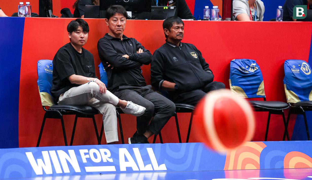 Pelatih Timnas Indonesia, Shin Tae-yong (tengah) bersama Direktur Teknik PSSI, Indra Sjafri (kanan) dan penerjemahnya Jeong Seok-seo saat menonton laga Grup H Piala Dunia FIBA 2023 antara Kanada melawan Latvia di Indonesia Arena, Senayan, Jakarta, Selasa (29/08/2023). (Bola.com/Bagaskara Lazuardi)