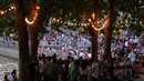 Orang-orang duduk saat berkumpul di tepi sungai Seine sebagai bagian dari acara musim panas Paris Plages di Paris, Prancis (7/7). (AFP Photo/Francois Guillot)