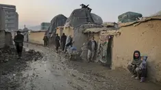 Seorang pria Afghanistan duduk di dinding ketika yang lain berjalan melalui jalan berlumpur di sebuah kamp di Kabul, Afghanistan (27/11/2019). Puluhan ribu warga Afghanistan yang terlantar secara internal tinggal di kamp-kamp, yang kekurangan fasilitas dasar, di Afghanistan. (AP Photo/Altaf Qadri)