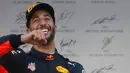 Pembalap Red Bull, Daniel Ricciardo mereyakan kemenangannya di atas podium usai menjuarai balapan GP Azerbaijan di Baku, Minggu (25/6). Kemenangan itu sekaligus menandai kesuksesan pertamanya meraih puncak pertama musim ini. (AP Photo/Darko Bandic)