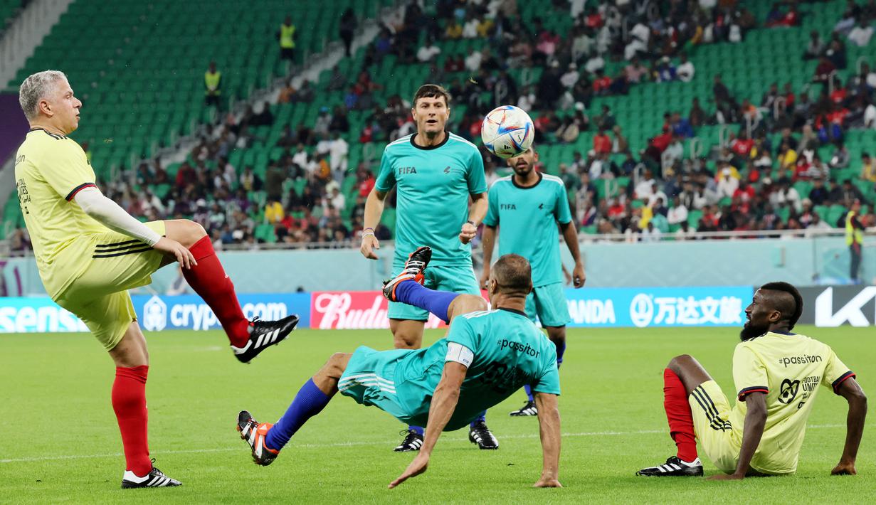 Legenda Brasil, Cafu, berusaha melakukan tendangan salto pada laga hiburan jelang semi final Piala Dunia di Stadion Al Thumama, Senin (12/12/2022). (AFP/Karim Jaafar)