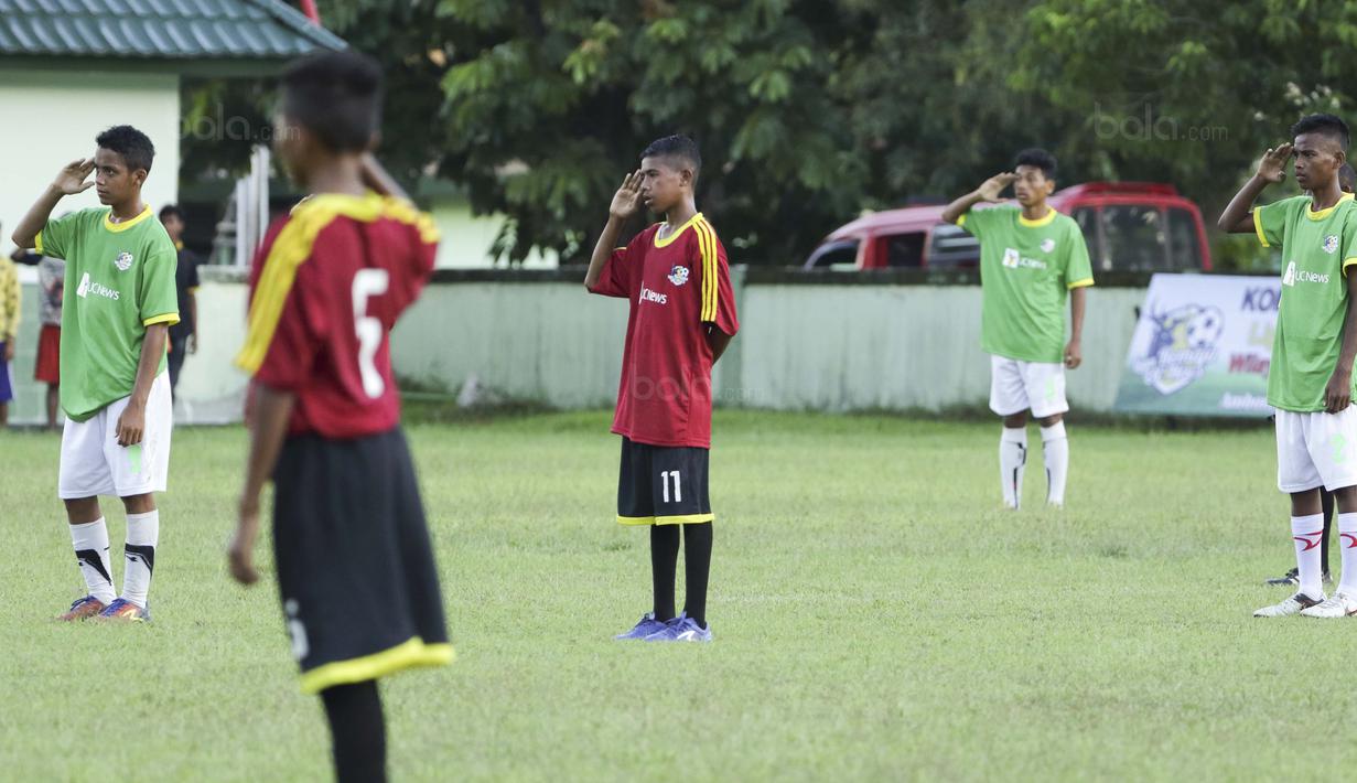 Para pemain SSB Maehanu dan SSB Persenal hormat bendera pada Liga Remaja UC News di Lapangan Masariku Yonif 733, Ambon, Selasa (28/11/2017). SSB Maehanu menang 1-1 (5-4) atas SSB Persenal. (Bola.com/Peksi Cahyo)