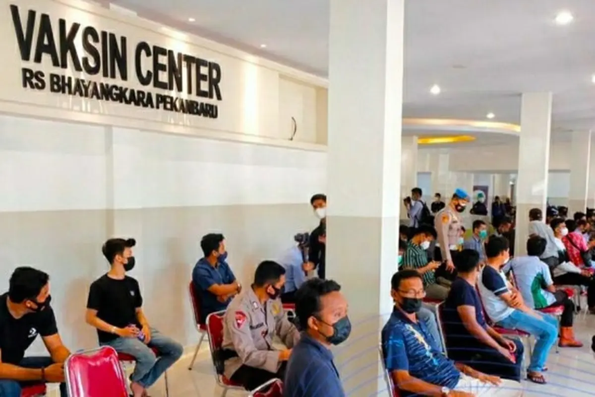 Warga mengantri di Vaksin Center Polda Riau untuk bisa menerima vaksin Covid-19.