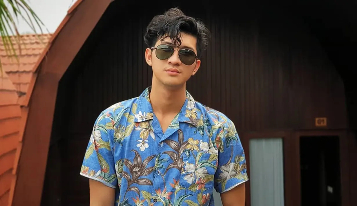 Saat berlibur, pria kelahiran 2000 ini tak lupa membawa kacamata berlensa gelap ini. Menggunakan kemeja bernuansa summer, penampilan Aditya Zoni semakin trendi.(Liputan6.com/IG/@real_aditya1)