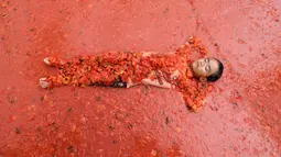 Seorang anak laki-laki berbaring di dalam kolam berisi tomat selama Festival Tomat di Hwacheon, Korea Selatan, 5 Agustus 2017. Festival untuk merayakan panen tomat ini berlangsung dari 4 - 7 Agustus. (AP Photo/Ahn Young-joon)