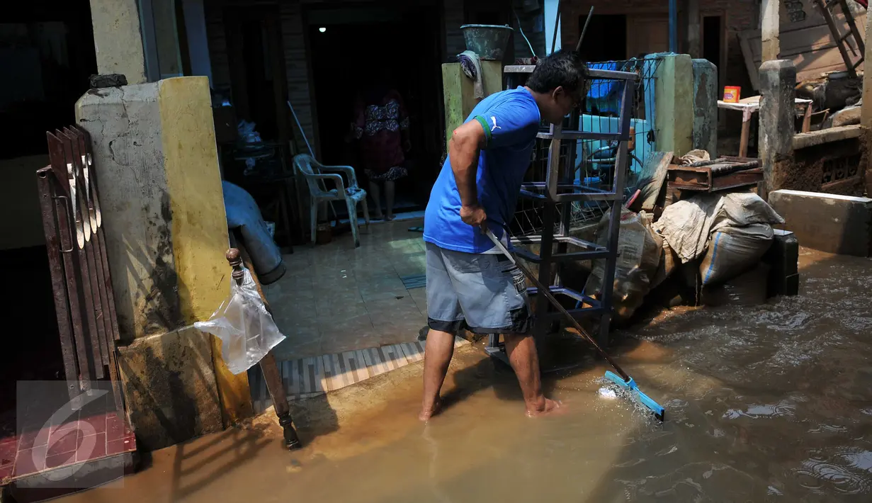 Warga Kampung Pulo, Kelurahan Kampung Melayu, Jatinegara, Jakarta, mulai melakukan aktivitas bersih-bersih menyusul surutnya air yang sempat merendam pemukiman mereka, Selasa, (17/11). (Liputan6.com/Gempur M Surya)