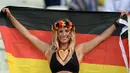 Sambil memegang bendera Jerman seorang suporter cantik ini memperlihatkan senyum indahnya sebelum Jerman berlaga melawan Ghana di The Castelao Stadium, Fortaleza (21/06/2014) (AFP PHOTO/CARL DE SOUZA)