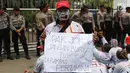 Seorang pria ikut menggelar aksi di depan gedung Pertamina, Jakarta, Senin (23/10). Aksi ini untuk menuntut hak atas PHK yang terjadi kepada mereka yang dilakukan oleh PT Pertamina Patra Niaga dan Elnusa Petrofin. (Liputan6.com/Angga Yuniar)