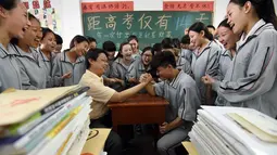 Siswa SMA beradu panco dengan gurunya sebelum ujian masuk perguruan tinggi di sebuah sekolah di Handan, Provinsi Hebei, China utara (24/5). Cara unik ini dilakukan sekolah-sekolah China agar para siswanya lebih rileks menghadapi ujian. (AFP PHOTO/STR)