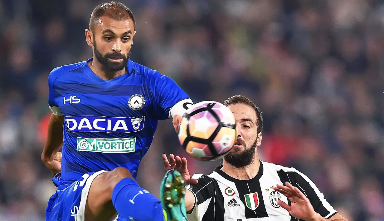 Pemain Juventus, Gonzalo Higuain berebut bola dengan pemain Udinese, Sven Kums (kiri)  pada lanjutan Serie A Italia di Stadion Juventus, Turin, Minggu (16/10/2016) dini hari WIB. (EPA/Alessandro Di Marco)