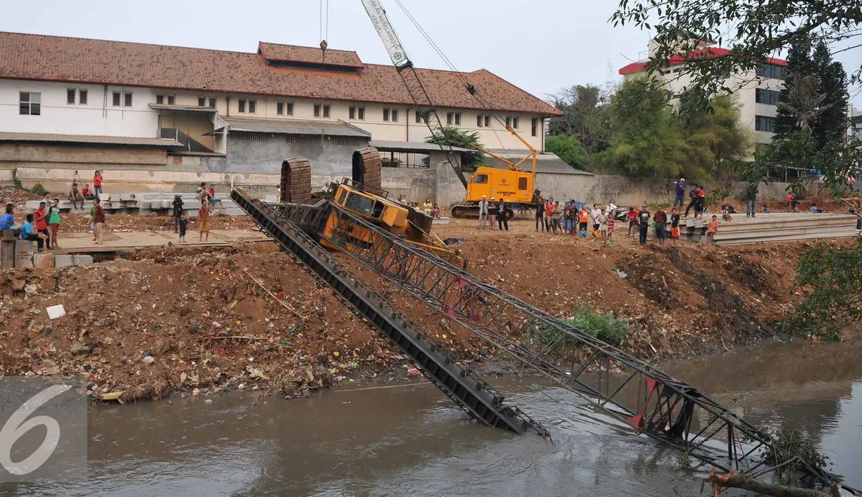 Crane untuk memasang turap di bantaran Kali Kampung Pulo jatuh ke Sungai Ciliwung (1/10/15) dan menimpa gubuk. Akibatnya, seorang warga RT15/10 Kelurahan Bukit Duri, Jakarta Selatan harus mendapatkan perawatan medis. (Liputan6.com/Gempur M Surya)