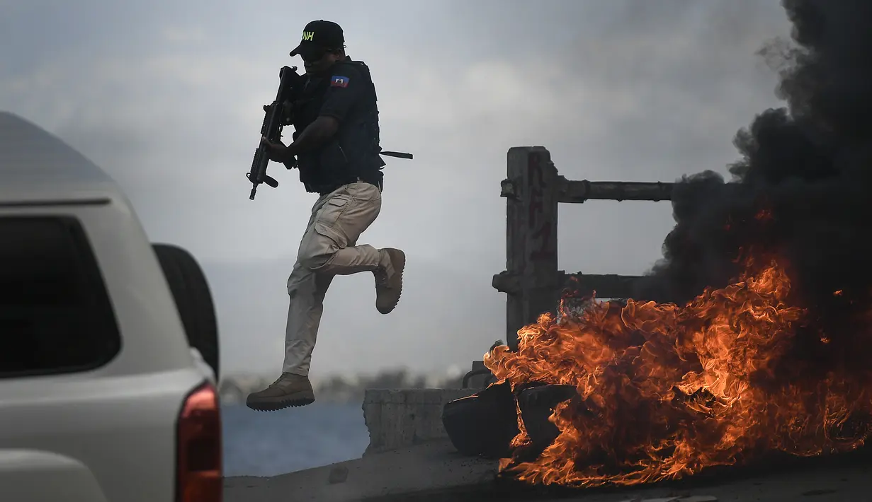 Polisi meninggalkan kendaraannya saat demonstrasi menuntut keadilan atas pembunuhan Presiden Haiti Jovenel Moise di Cap-Haitien, Haiti, Kamis (22/7/2021). Demonstrasi menuntut keadilan atas pembunuhan Presiden Haiti Jovenel Moise terus berlanjut dan menimbulkan kerusuhan. (AP Photo/Matias Delacroix)