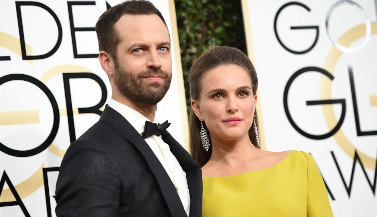 Natalie Portman didampingi suaminya, Benjamin Millepied berpose di karpet merah acara penghargaan Golden Globe Awards 2017 di California, AS, Minggu (8/1). Sang koreografer tampil gagah dengan setelan jas hitamnya. (AFP PHOTO/Valerie MACON)
