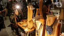 Pengunjung mengamati produk yang dipamerkan pada pameran International Handicraft Trade Fair (INACRAFT) di Jakarta Convention Center (JCC), Senayan, Jakarta, Kamis (24/3/2022). Setelah vakum selama dua tahun lamanya, Jakarta INACRAFT akhirnya akan kembali digelar. (Liputan6.com/Johan Tallo)