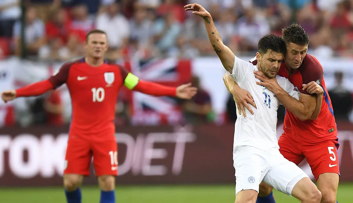 Bek Inggris, Gary Cahill, menahan laju penyerang Slovakia, Michal Duris. Namun meskipun menguasai jalannya laga, serangan timnas Inggris tidak efektif terbukti dari sulitnya mereka mencetak gol. (AFP/Joe Klamar)
