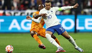 Pemain Timnas Prancis, Kylian Mbappe (kanan) berebut bola dengan pemain Timnas Belanda, Lutsharel Geertruida pada laga Grup B Kualifikasi Euro 2024 yang berlangsung di Stade de France, Sabtu (25/03/2023) WIB. Les Bleus menang dengan skor 4-0. (AFP/Anne-Christine Poujoulat)