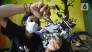 Perajin Wawang Kurniawan (38) menyelesaikan pembuatan miniatur motor RX King di Kelurahan Serua, Ciputat, Tangerang Selatan, Sabtu (17/10/2020). Miniatur dari limbah korek api, pipa plastik, kabel, kaleng minuman, dan kawat itu dijual seharga Rp 400 - Rp 450 ribu per unit. (merdeka.com/Dwi Narwoko)