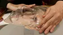 Pengunjung menyentuh foto 3D Vladimir Putin di perpustakaan khusus tunanetra di Siberia, Rusia (15/3). Foto 3D tersebut dibuat untuk para tuna netra yang tidak mengetahui bagaimana wajah dan sosok Vladimir Putin. (REUTERS/Ilya Naymushin)