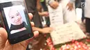 Keluarga menunjukkan foto Laila Sari saat dimakamkan di Tempat Pemakaman Umum (TPU) Karet Bivak, Jakarta, Selasa (21/11). Laila Sari meninggal dunia saat pulang syuting, di usai 82 tahun. (Liputan6.com/Herman Zakharia)