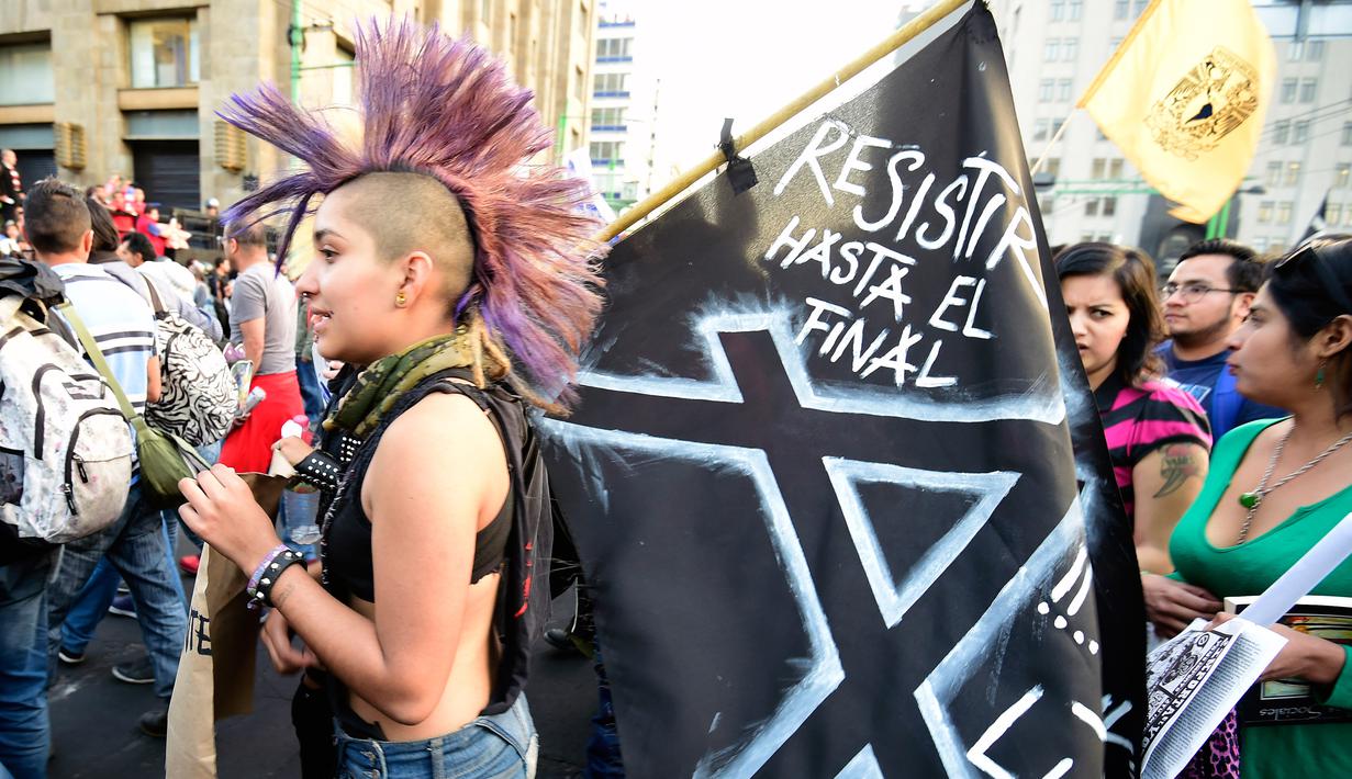 Anak Punk membawa bendera menolak kenaikan harga BBM, Mexico City, Meksiko (9/1). Keputusan pemerintah Meksiko menaikkan harga Bahan Bakar Minyak hingga 20 persen per tanggal 1 Januari 2017 memicu amarah warganya. (AFP/Alfredo Estrella)