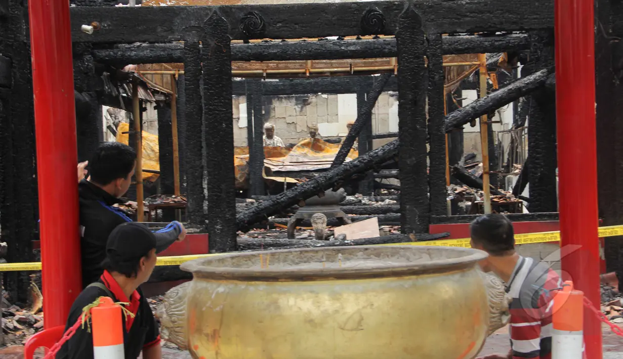 Sejumlah warga duduk di sekitar sisa-sisa kebakaran Wihara Dharma Bakti, Petak Sembilan, Jakarta, Kamis (19/3/2015). Wihara yang lebih dikenal dengan Petak Sembilan ini terbakar pada 2 Maret 2015 lalu. (Liputan6.com/Helmi Afandi)