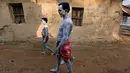 Penganut Hindu berjalan dengan mengecat sekujur tubuhnya selama ritual dari festival keagamaan Siwa Gajan di Bengal Barat , India , (11/4).Dalam ritualnya penganut akan berdoa kepada Dewa Siwa agar dikabulkan keinginannya. (REUTERS / Rupak De Chowdhuri)