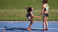 Pelari Selandia Baru, Nikki Hamblin (kanan), menolong pelari Amerika Serikat, Abbey D'Agostino (kiri), pada babak penyisihan atletik nomor 5.000 meter putri Olimpiade Rio de Janeiro, Selasa (16/8/2016). (AFP/Johannes Eisele)