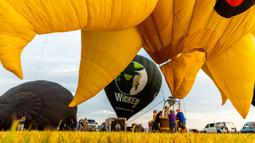 Kru memompa balon udara pada New Jersey Lottery Festival of Ballooning di Bandara Solberg, Readington, New Jersey, Amerika Serikat, 29 Juli 2022. Festival yang berlangsung hingga 31 Juli ini akan menampilkan sebanyak 100 balon. (AP Photo/Julia Nikhinson)